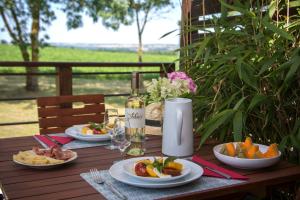 a wooden table with plates of food on it at Les Hauts de Condom Appartements Climatises in Condom