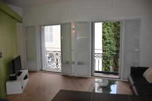 un soggiorno con porte scorrevoli in vetro e balcone. di APPART AIX MAZARIN ad Aix en Provence