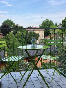 een groene tafel en 2 stoelen op een balkon bij Home Sweet Home in Treviso