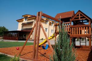 a playground with a slide in front of a house at Penzión MAX in Podhájska