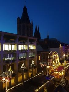 Eine nachts beleuchtete Stadt mit Weihnachtslichtern in der Unterkunft Old Town View in Köln