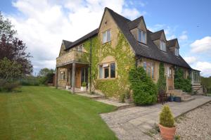 a house covered in ivy with a yard at Woodland Guesthouse in Stow on the Wold