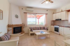 a living room with a couch and a fireplace at Felicia's sun-side house in Kastraki