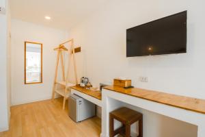 Habitación con escritorio y TV en la pared. en Whalecome Aonang Resort-SHA Extra Plus en Ao Nang Beach