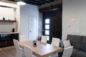 comedor con mesa de madera y sillas blancas en Mercedes Etxea, en Cripán