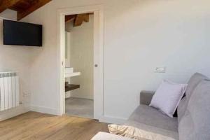 Una sala de estar con un sofá y un televisor de pantalla plana. en Mercedes Etxea, en Cripán