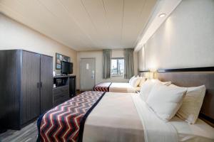 a hotel room with two beds and a television at Carlton Inn Midway in Chicago