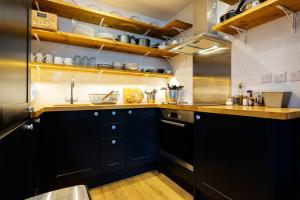 a kitchen with black cabinets and a sink at Veeve - Sinclair Sophistication in London