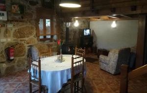 - une table et des chaises dans une pièce dotée d'un mur en pierre dans l'établissement Quinta do Pé Longo - Serra da Estrela, à Cortes do Meio