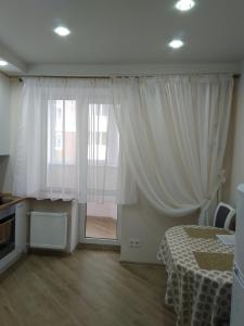 a bedroom with a bed and a window with curtains at Подобово апартаменти в м Буча in Bucha