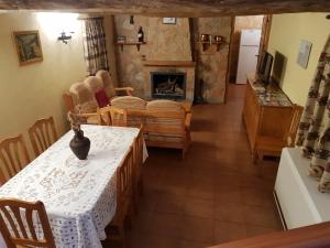 comedor con mesa y chimenea en Casa Rural Barba, en Fuente-Higuera