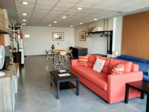 sala de estar con sofá rojo y mesa en Studio Loft Fuerteventura, en Puerto del Rosario