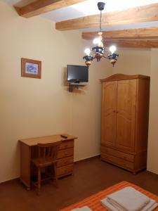 1 dormitorio con escritorio y TV en la pared en Casa Rural Barba, en Fuente-Higuera