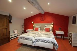 - une chambre avec un grand lit et un mur rouge dans l'établissement Ferme du Pic d'Allier, à Saint-Martin-le-Supérieur