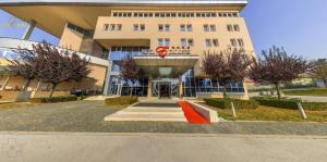 a large building with a red ramp in front of it at Hotel Exclusive in Sarajevo