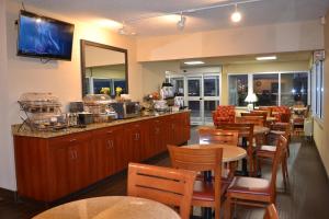 a restaurant with tables and chairs and a bar at Baymont by Wyndham Effingham in Effingham