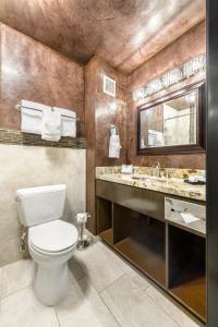 
a bathroom with a toilet a sink and a mirror at Ellis Island Hotel Casino & Brewery in Las Vegas
