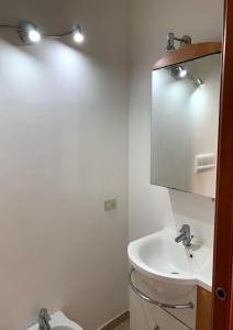 a white bathroom with a sink and a mirror at Luxury Sorrento House in Sorrento