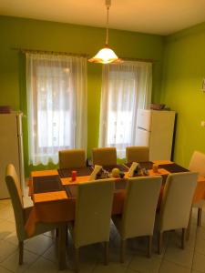 a kitchen with a dining room table and chairs at Kristály Apartmanház in Sárvár