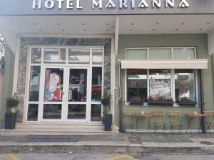 een jachthaven met twee tafels en stoelen voor een gebouw bij Marianna Hotel in Alexandroupoli