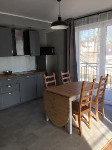a kitchen with a wooden table and chairs in a kitchen at apartament 6 Villa Mountain View in Szklarska Poręba