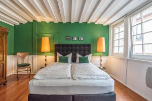 ein Schlafzimmer mit einem Bett mit grünen Wänden und 2 Lampen in der Unterkunft Privatzimmer in bester Altstadtlage in Tübingen