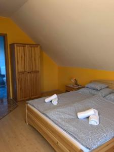 1 dormitorio con 1 cama con 2 toallas en Kristály Apartmanház, en Sárvár