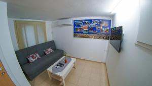 een kleine woonkamer met een bank en een schilderij bij Private place near carmel center in Haifa