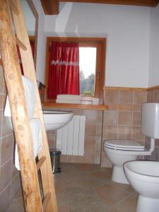 a bathroom with a toilet and a sink and a window at Au Coeur in Verrayes