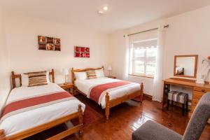 una camera con 2 letti, una scrivania e una sedia di Nellie Dee's - Room Only a Doolin