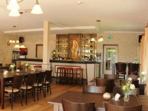 a restaurant with tables and chairs and a bar at Hotel Kreutzer in Heijenrath