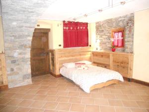 a bedroom with a bed and a stone wall at Au Coeur in Verrayes