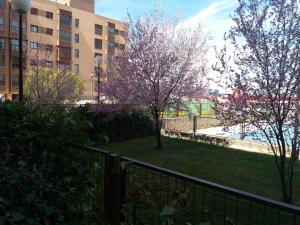 widok na park z drzewami i płotem w obiekcie My Suites Madrid - Aeropuerto Ifema w Madrycie