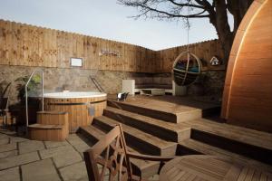 un patio con escaleras de madera, un lavabo y un árbol en The Impeccable Pig en Sedgefield