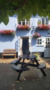 a picnic table in front of a building with flowers at The Castle Inn in Bungay
