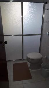 a bathroom with a toilet and a glass door at Vila Caiçara Nice Location - Linda Vista ! in Solemar