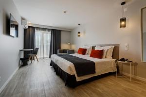 um quarto de hotel com uma cama grande com almofadas vermelhas em Sport Hotel Gym + SPA na Covilh�