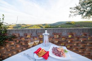 einen Tisch mit zwei Gläsern Wein und einem Teller Essen in der Unterkunft Agriturismo la Preara in Monteforte dʼAlpone