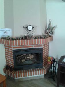 a brick fireplace with a clock on top of it at Plaza Principal Zahara - MAGNIFICA UBICACION y VISTAS in Zahara de la Sierra