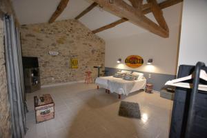 a bedroom with a bed and a stone wall at CHAMBRE D’HÔTES NATURE ET SAVEURS in Boutenac +124 photos