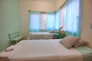 una camera con due letti e una finestra con tende blu di Paziflora Hostel -STARLINK- a Puerto Escondido