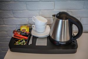 a tea kettle and a cup on top of a counter at Pensjonat Augustyniak in Ostrołęka