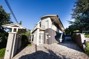 une grande maison blanche avec une allée en briques dans l'établissement Csenge Villa, à Siófok