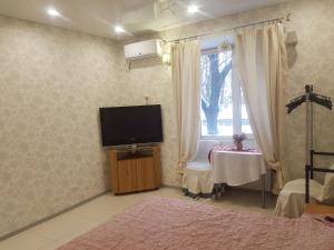 Schlafzimmer mit einem TV, einem Tisch und einem Fenster in der Unterkunft вулиця 29-го Вересня 2\25 in Krementschuk