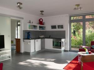 a kitchen with white cabinets and a red rug at Schwarzes Schaf in Kleve
