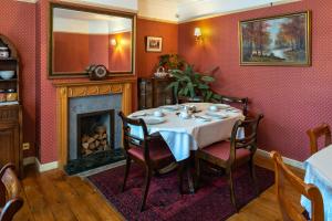 a dining room with a table and a fireplace at Cambridge Bed & Breakfast in Cambridge