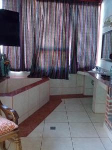 a bathroom with a tub and a window with curtains at Hotel Nuestro Sueño in San Antonio Palopó