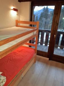 a bedroom with two bunk beds and a balcony at Saint Gervais - Le Bettex T3 Duplex (1400m d'altitude)/ 55m2 / Vue Mont Blanc - Aux Pieds des Pistes! in Saint-Gervais-les-Bains