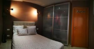 1 dormitorio con cama y armario de cristal en White Stones Beach In Sant Pol de Mar, en Sant Pol de Mar