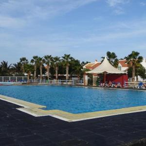 a large swimming pool with a tent and palm trees at Solmar apartment in Beirona